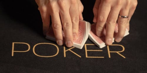 Hände, die Poker-Karten mischen